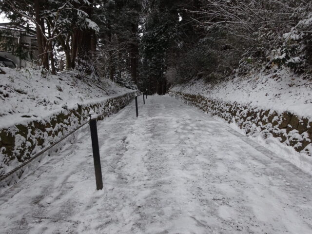 雪の積もった月見坂を登る